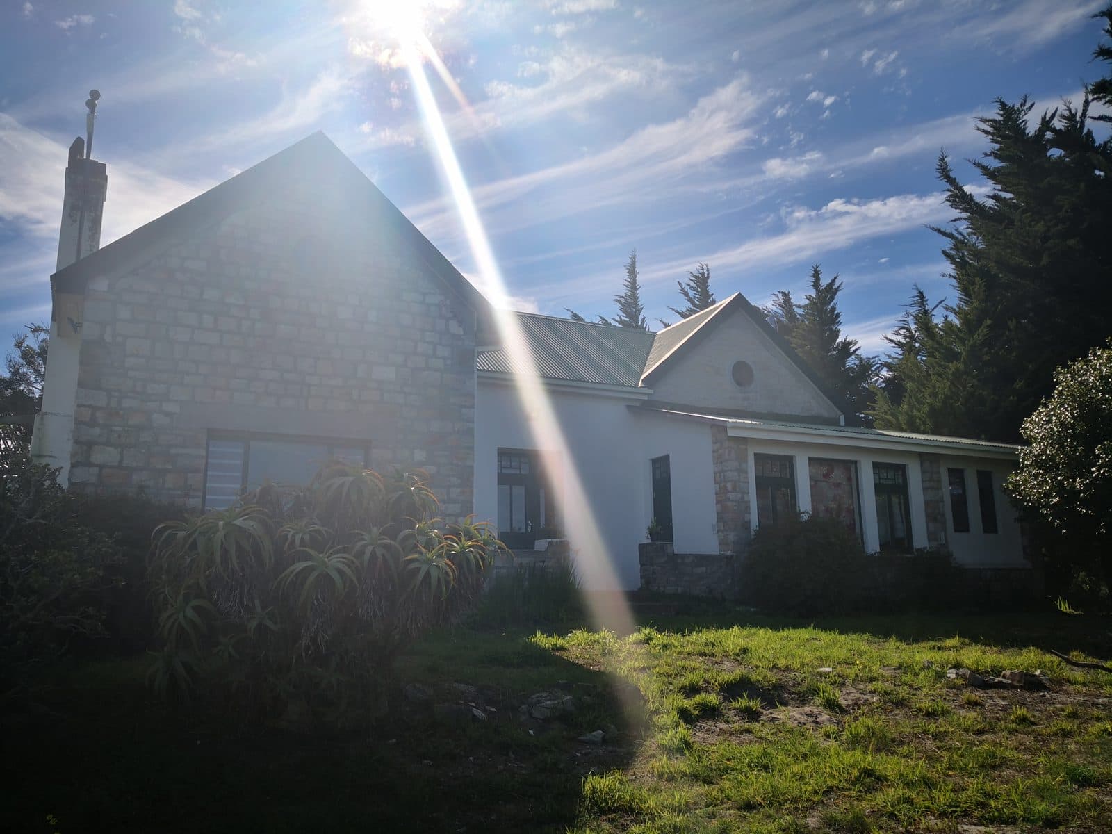 The old stone manor house — gables and aloes under a sunbeam.